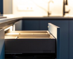 Vertical angle of a pull-out kitchen drawer in a deep blue cabinet. Warm lighting reveals refined textures and space depth. SSUCv3H4sIAAAAAAAAA41Py46DMAz8F5+DlEAXSn6l6iEPl1oFUiXOViuUf1+FUu11bzO25+ENyIOGvm/dGZVshm7sG6VushnNaWjkrbdoW6/GFkGAN4ygVdeNo2pPX2rozr2UUgqwJpEDvQHNc04cDVNYQUsBEVePcYfoiUMkM4OWRUBiwzlhAr0VAc4wTiHSzj9+l63OQQMISNlWUMQ/Z1cBZsLV/VT/UovMaPa4y1XA48UYlyM78L1WrPAZydE6HZ1y4rC88Rq4avcEDu5B/hC/37hT4hBrFuTnHIxHf6yzXYj5QyN+E77+rkspv0sImgiEAQAA